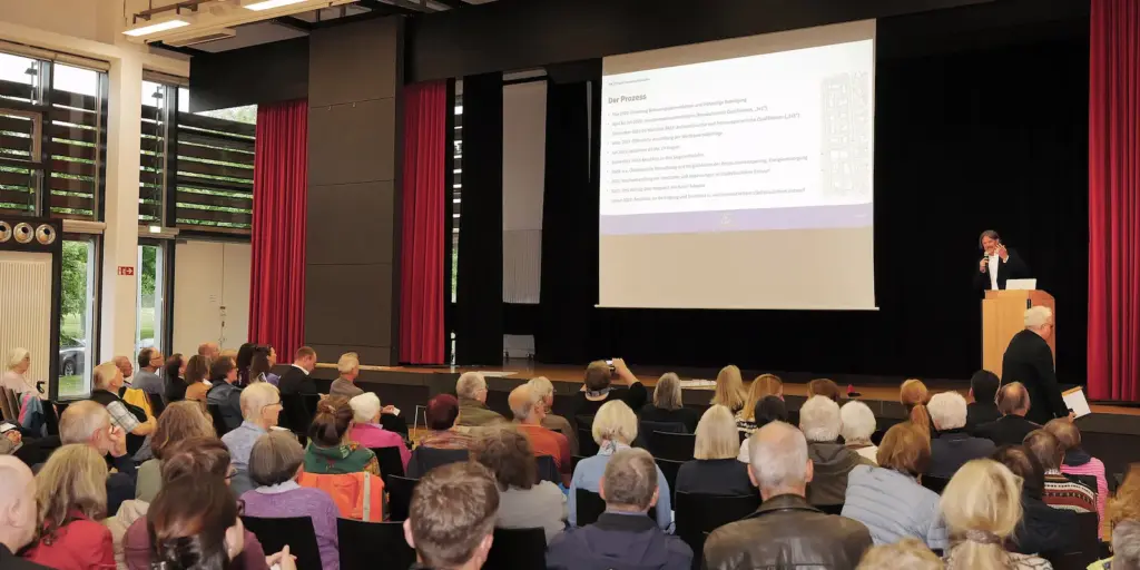 Publikum bei der KaepseLE-Bürgerversammlung in dem Saal des Walter-Schweizer-Kulturforums in Leinfelden-Echterdingen; auf der Bühne präsentiert der erste Bürgermeister Benjamin Dihm von Leinfelden-Echterdingen den aktuellen Stand des Projekts.